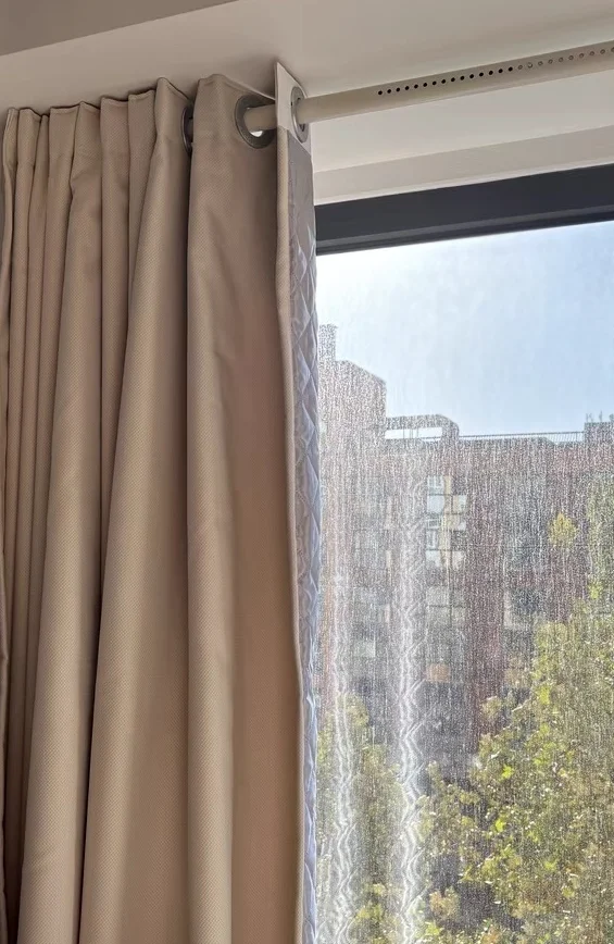 Rideau phonique sur-mesure devant une fenêtre sur rue chez Loïc B.
